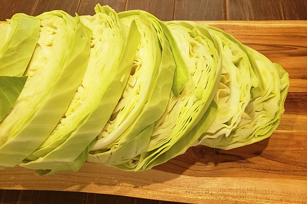 Sliced, raw cabbage on a wooden cutting board