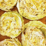 Cooked cabbage steaks on a sheet pan