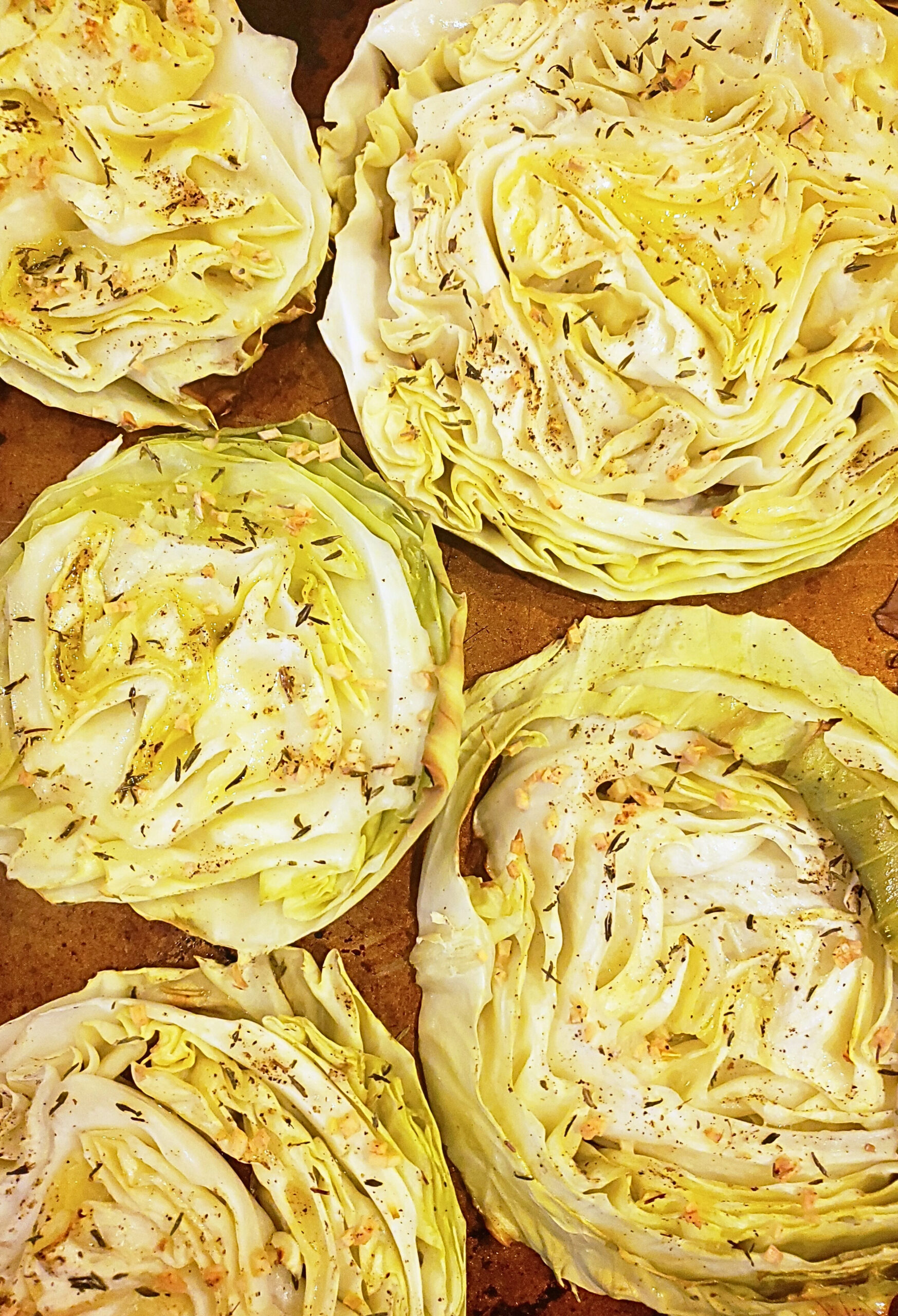 Close up shot of completed cabbage steaks on a baking sheet