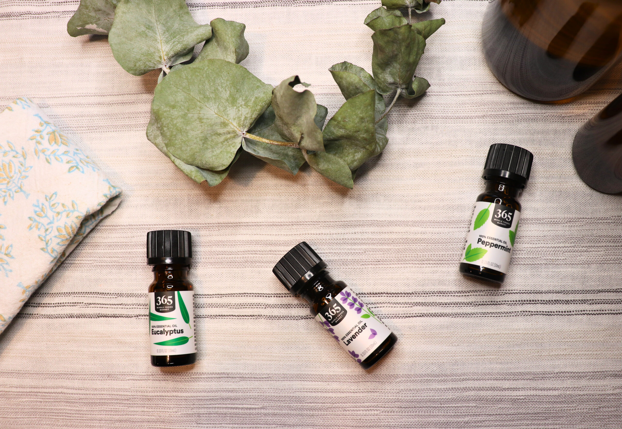 Bottles of essential oils next to other all natural cleaning products and ingredients