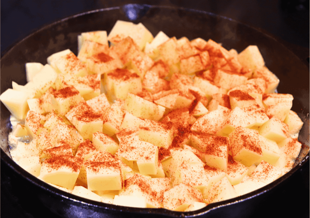 Cast iron skillet with potatoes and seasonings process photo