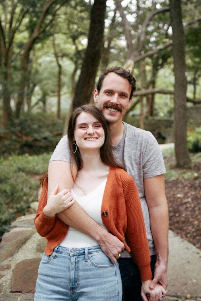 A happy couple in a park smiling.
