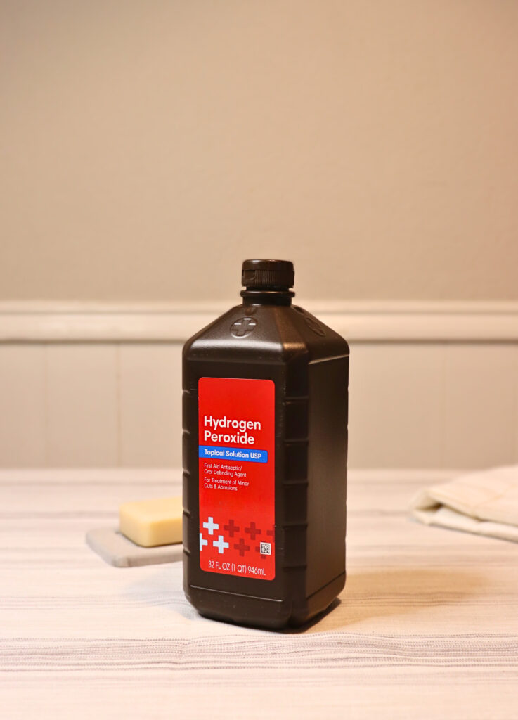 Bottle of hydrogen peroxide by a bar of natural soap for cleaning