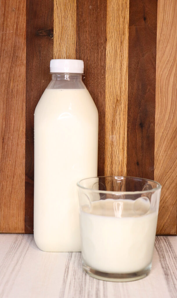 Bottle of raw milk by a glass of milk