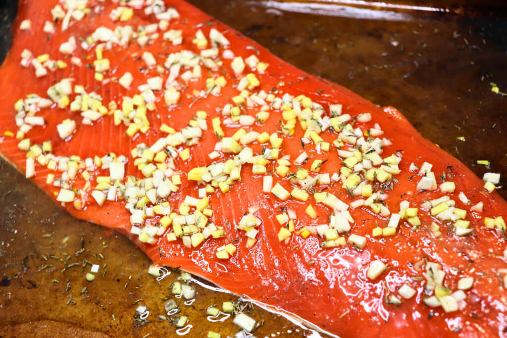 Raw salmon with butter garlic marinade ready to bake