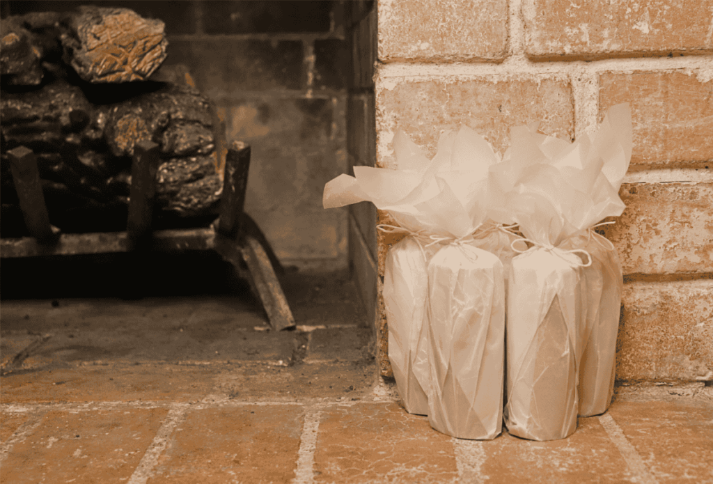 Lint fire starter logs wrapped in wax paper by a fireplace