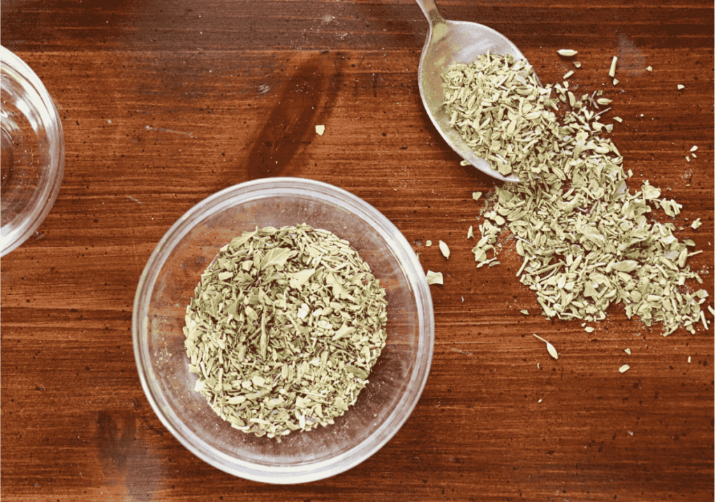 Bowl of mixed herbs by a spoonful of the same blend