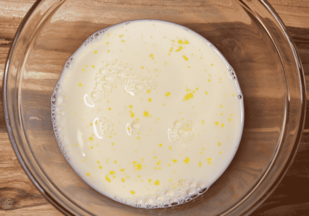 Glass bowl with milk and egg mixed in it for breading