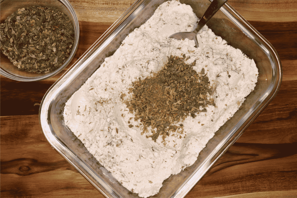Glass shallow dish with flour and herb mixture to make breading for the steak fingers
