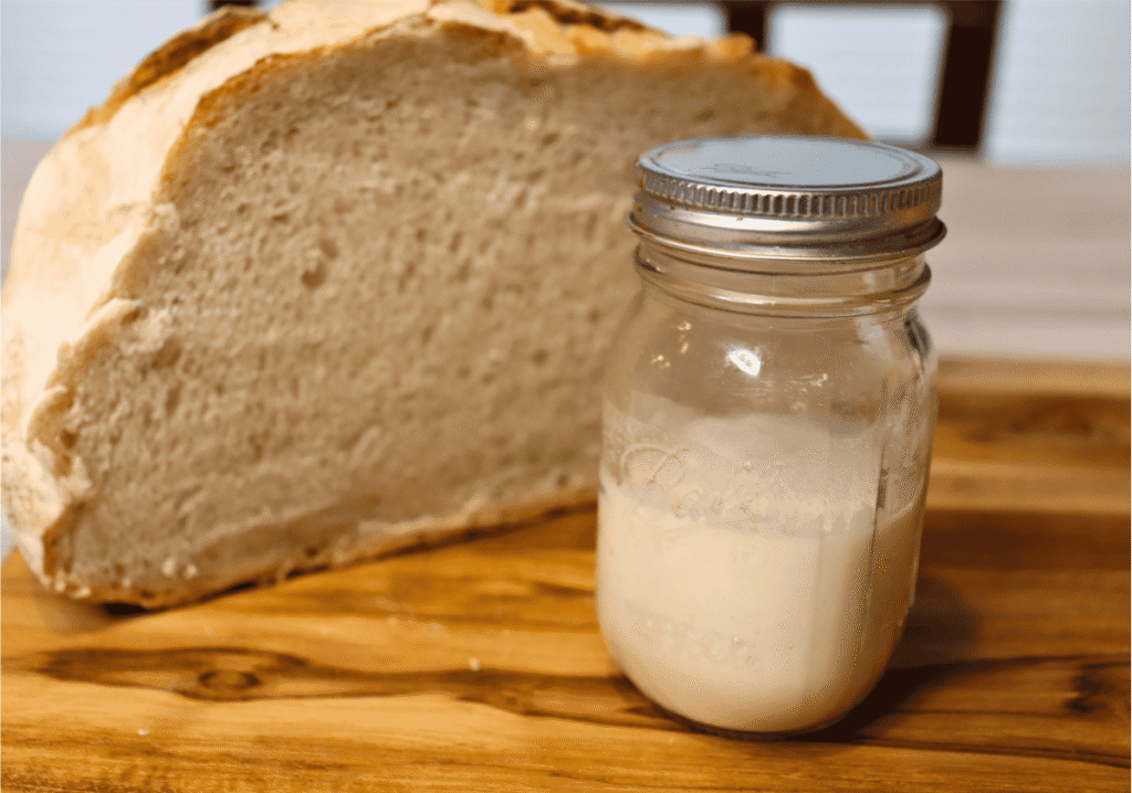 Small sourdough starter next to sourdough bread