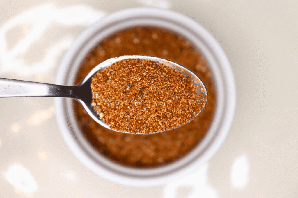 Close-up shot of a spoonful of cajun seasoning with the bowl in the background