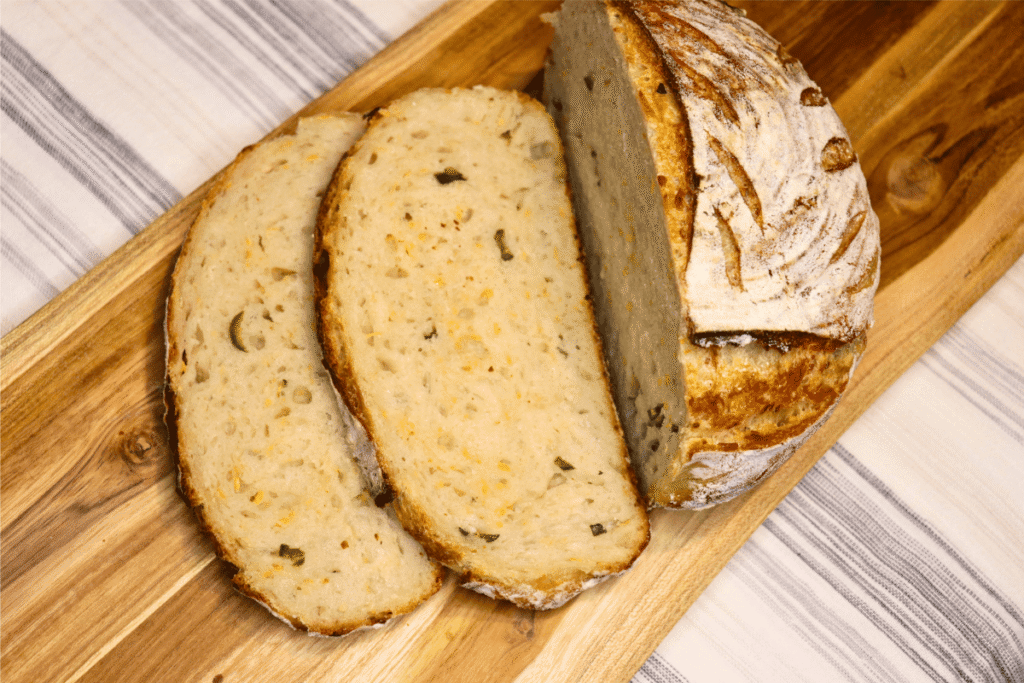 Sliced Jalapeño Cheddar Sourdough bread on a wooden board