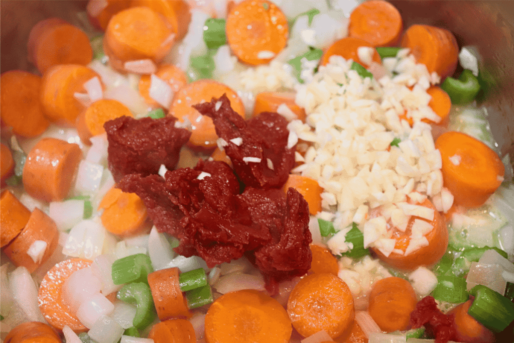 Tomato paste and garlic on top of mixed vegetables