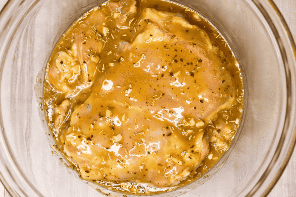 Marinated chicken thighs in a glass bowl