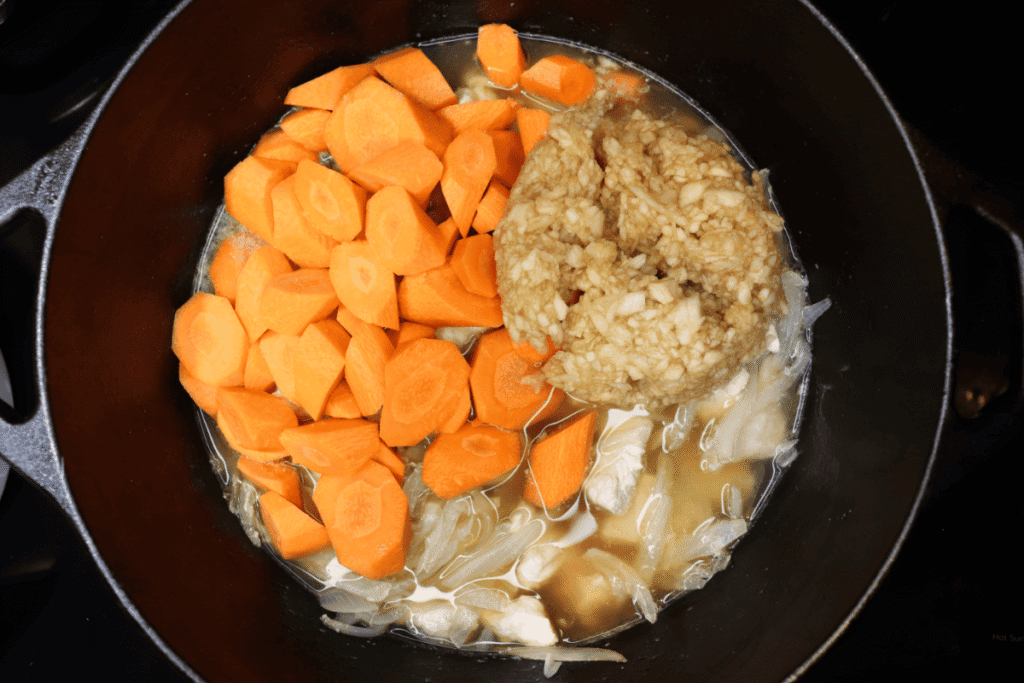carrots and pureed pear simmering in a dutch oven